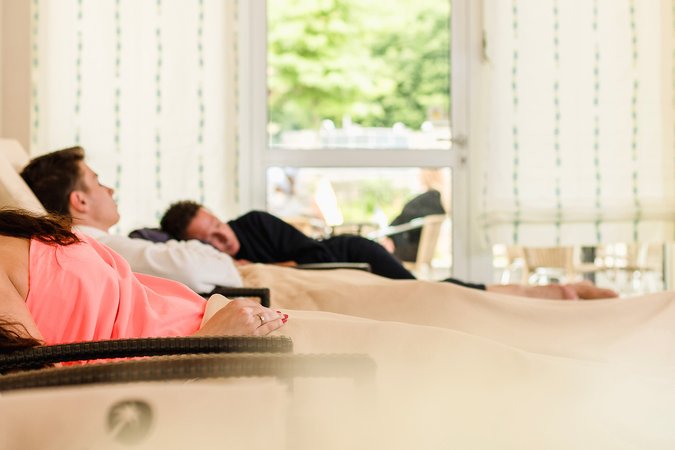 Entspannen in der Saunawelt der Copa Oase Menschen entspannen sich auf Liegen im Ruheraum