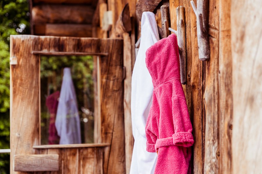 Bademantel und Handtuch hängt am äußeren Haken des Saunahauses