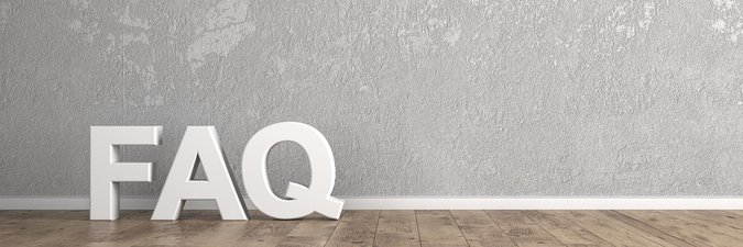 Brauner Holzleistenboden vor grau gesprenkelter Wand, weiße Holzbuchstaben "FAQ" an der Wand lehnend