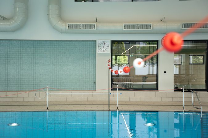 Blick über das Schwimmbad, im Hintergrund Fenster und Lüftung.