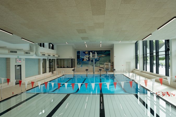 Blick über das Schwimmerbecken, vorne der nagelneue Hubboden, hinten der Sprungturm.