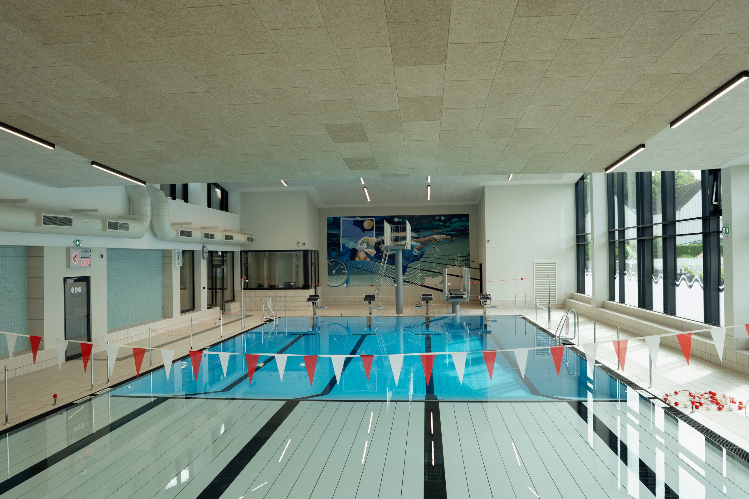 Blick über das Schwimmerbecken, vorne der nagelneue Hubboden, hinten der Sprungturm.