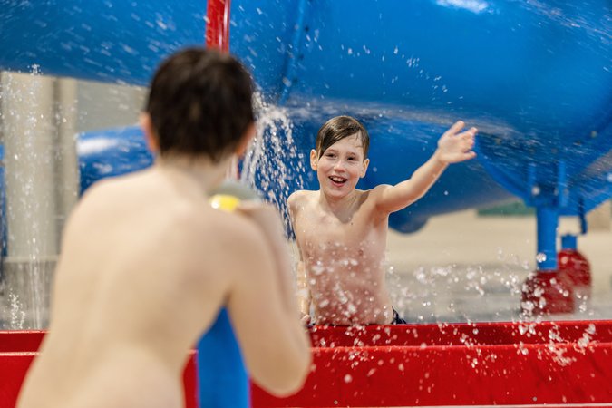 Zwei Jungs spielen mit Wasserkanonen auf dem Wasserspielplatz