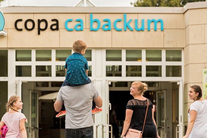 Eine Familie mit drei Kindern befindet sich im äußeren Eingangsbereich des Copa Ca Backum
