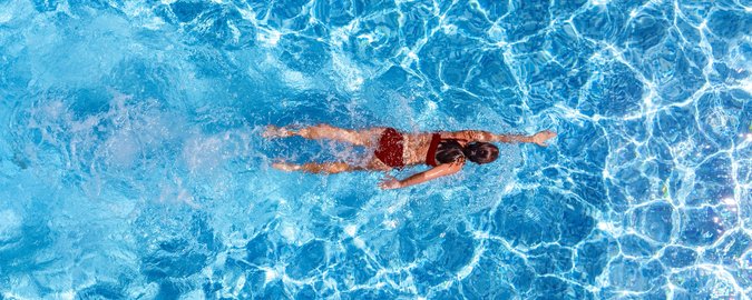 Ein Mädchen schwimmend aus der Vogelperspektive