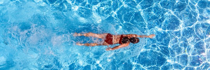 Ein Mädchen schwimmend aus der Vogelperspektive